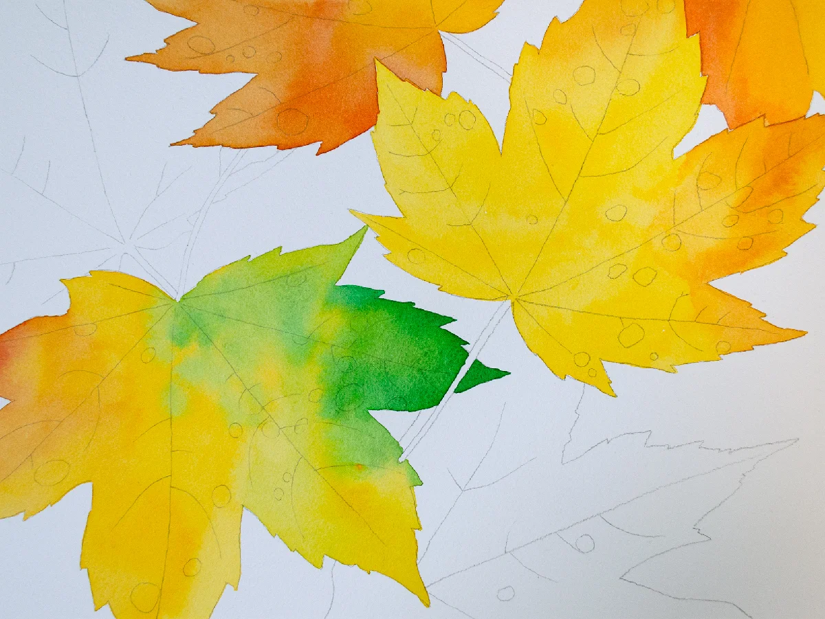 Autumn leaves watercolor painting in progress with yellow, orange, red, and green washes